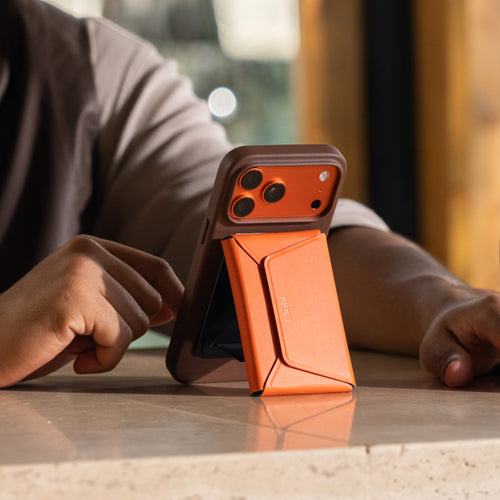 カカオブラウンのMOFT iPhone 17ケースとサンライズオレンジのMOFTカードケース＆スマホスタンド。動画視聴が楽しめる、最新のiPhoneケース（iPhone 17）とのおしゃれなコーディネート。